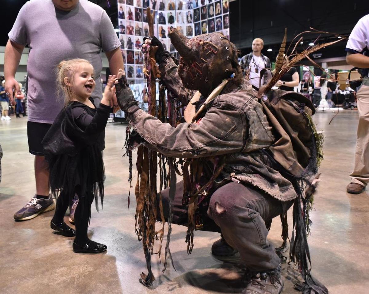 Ember Stull, 4, of Richmond high-fived Jerry Dewayne Lester, dressed as a character called Hockomock.