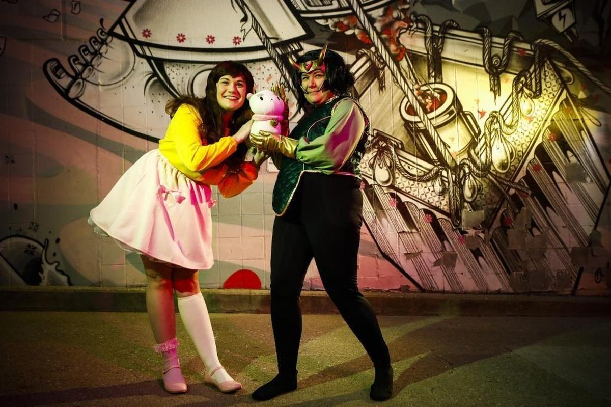 Jillian Krouse, dressed as Bee from the animated series “Bee and PuppyCat,” left, and Jessica Krouse, dressed as Loki as he appeared in the comic book series “The Unbeatable Squirrel Girl” in front of the Moonshine mural on Short Street.