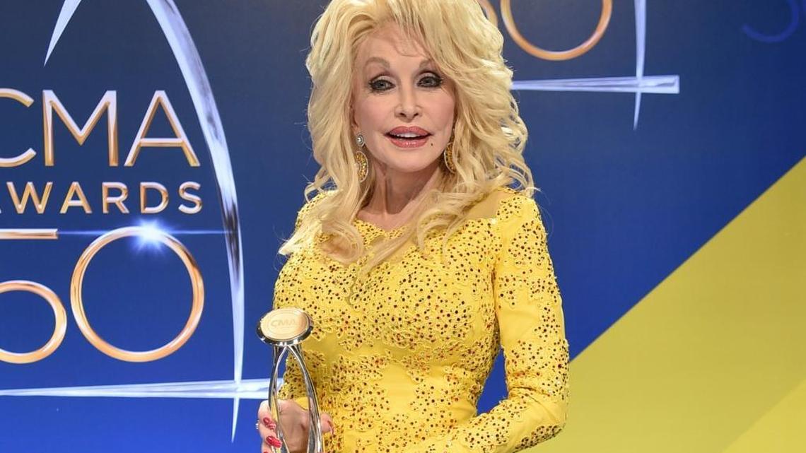 Dolly Parton posed in the press room with the Willie Nelson Lifetime Achievement Award during the 50th annual CMA Awards in Nashville, Tenn. Parton said she’s heartbroken about the wildfires that tore through the Tennessee county where she grew up.