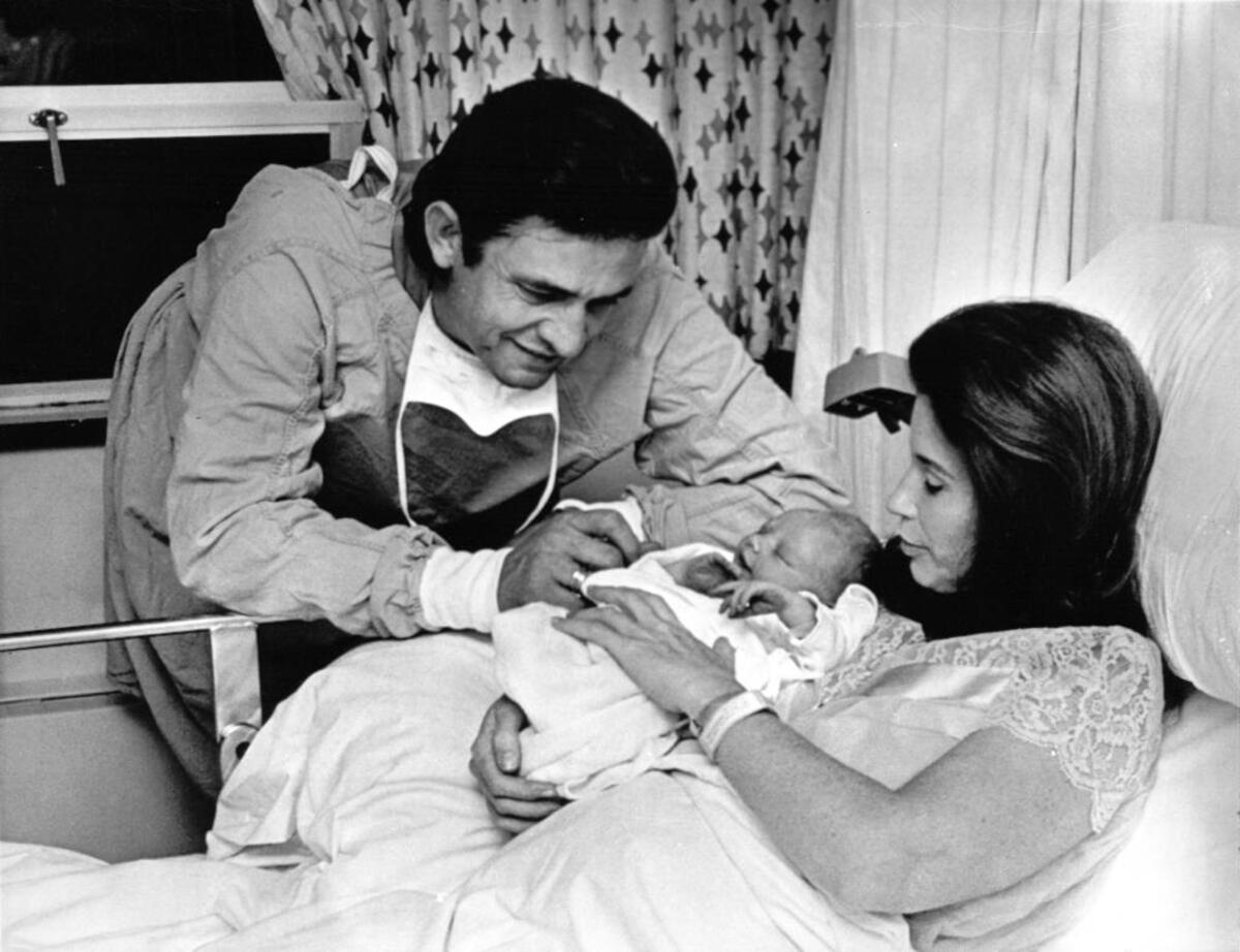 Johnny Cash and June Carter look at their newborn baby John Carter Cash in hospital in Nashville, Tennesse, March 7, 1970. John Carter Cash is now a successful musician and producer, working with artists such as Loretta Lynn.
