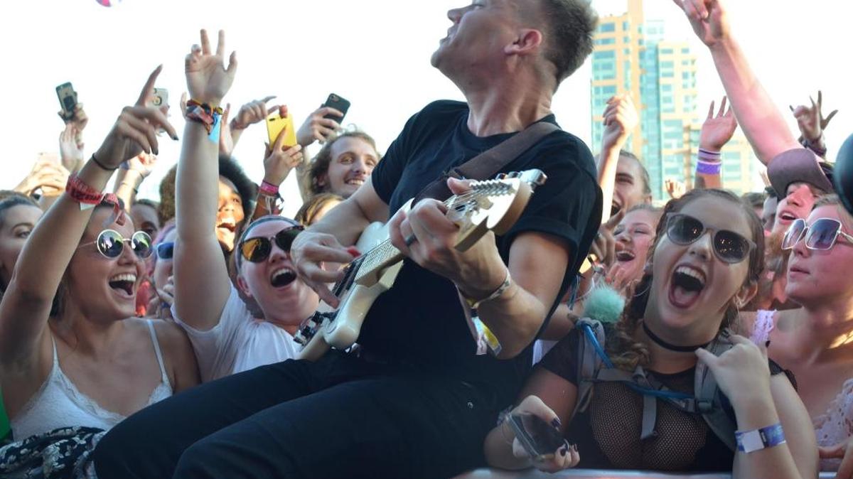 Cage the Elephant’s Brad Shultz went to the crowd to play part of the band’s set on Friday at the Forecastle Festival at Waterfront Park in Louisville.