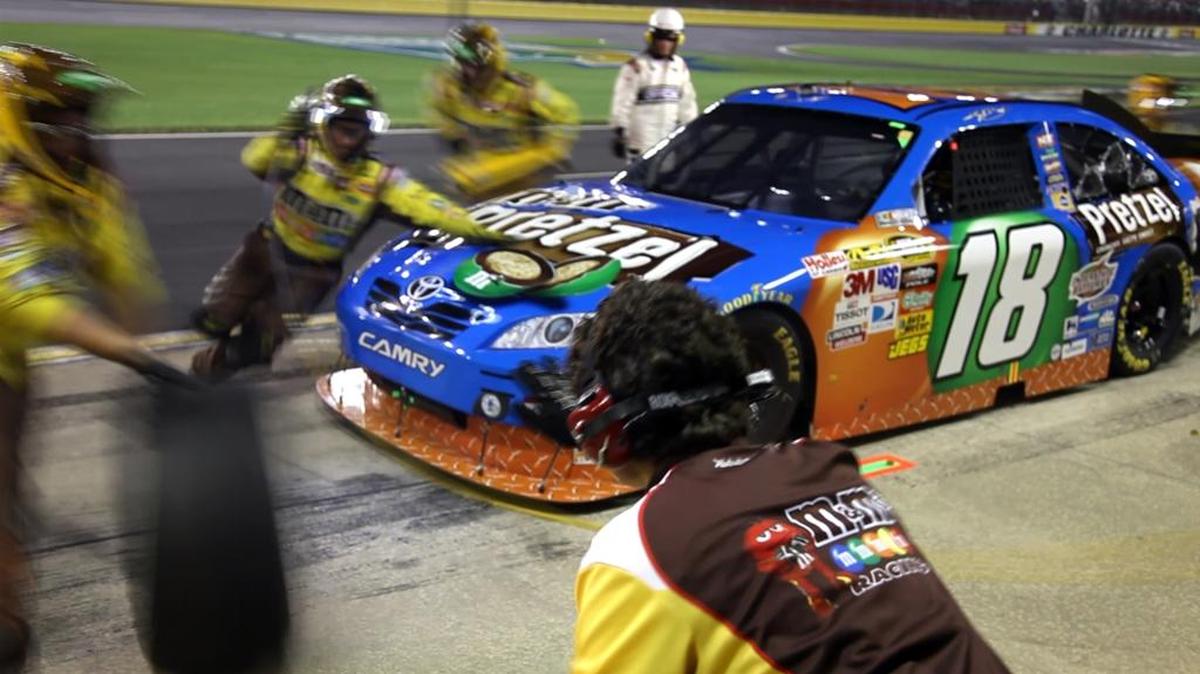 Janet Biggs video, “Duet,” juxtaposes NASCAR pit crews in action with a classical violinist and singer.