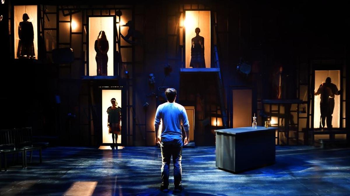 Aaron Botts as Anon looking at the shadows of refugees who’ve disappeared or died in Transylvania University Theatre’s production of Naomi Iizuka’s “Anon(ymous).”