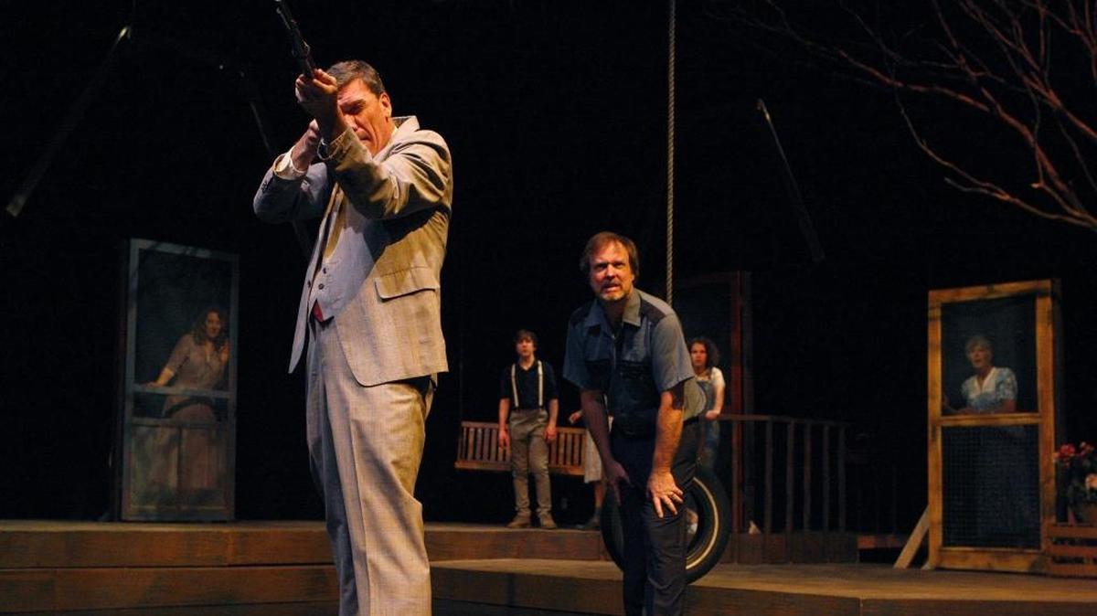 Kevin Crowley, as Atticus Finch, shoots a rabid dog. Behind him is Stuart Fail as Maycomb County Sheriff Heck Tate.