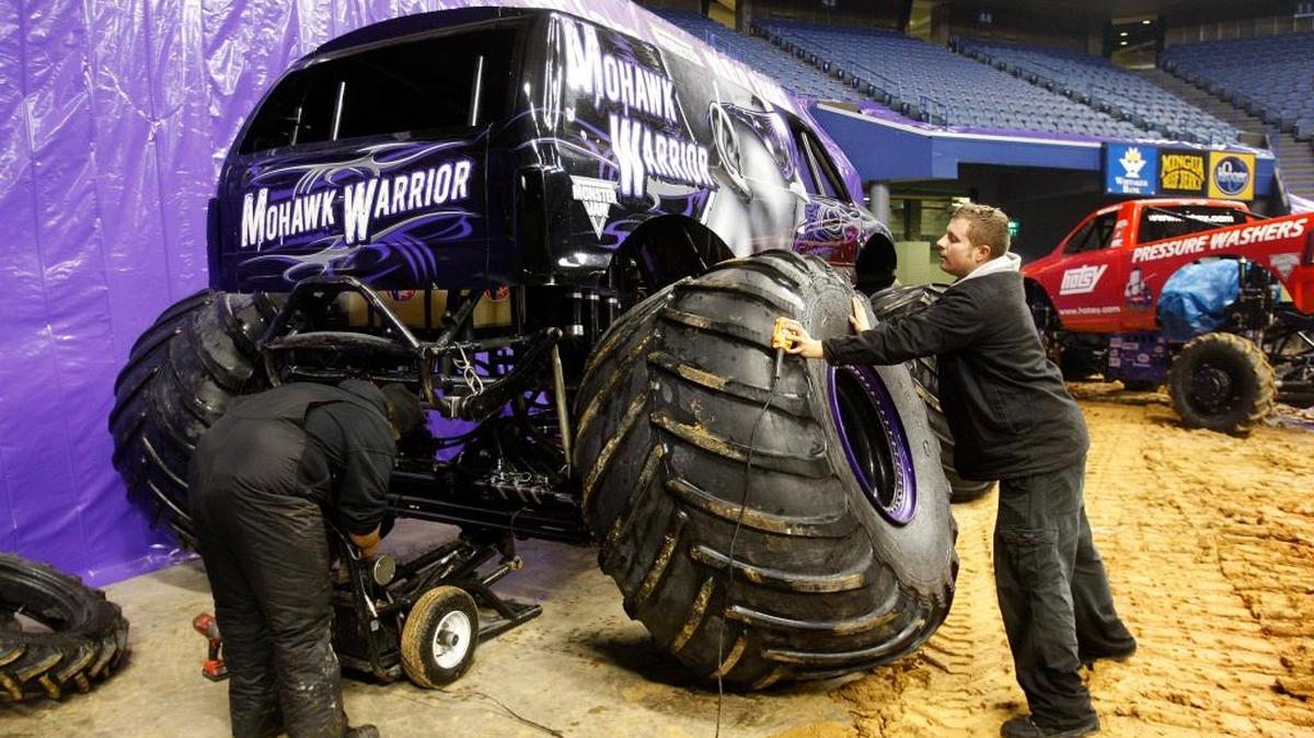 Asst. crew chief Phillip Norman, left, and crew chief Christian Norman, who is also Phillip's brother, work to put tires on the Mohawk Warrior in advance of Saturday's Monster Jam at Rupp Arena in Lexington, Ky., Friday, January 23, 2015. Photo by Matt Goins