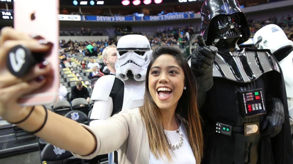 Lizelle Lauron, left, takes a photo of herself with an NBA fan dressed up as Darth Vader before an NBA basketball between the Indiana Pacers and Dallas Mavericks game in Dallas, Friday, Dec. 9, 2016. The iconic “Star Wars” villain will be the subject of a roast by the Louisville comic troupe Character Assassination on Dec. 23 at Comedy Off Broadway in Lexington, Ky.