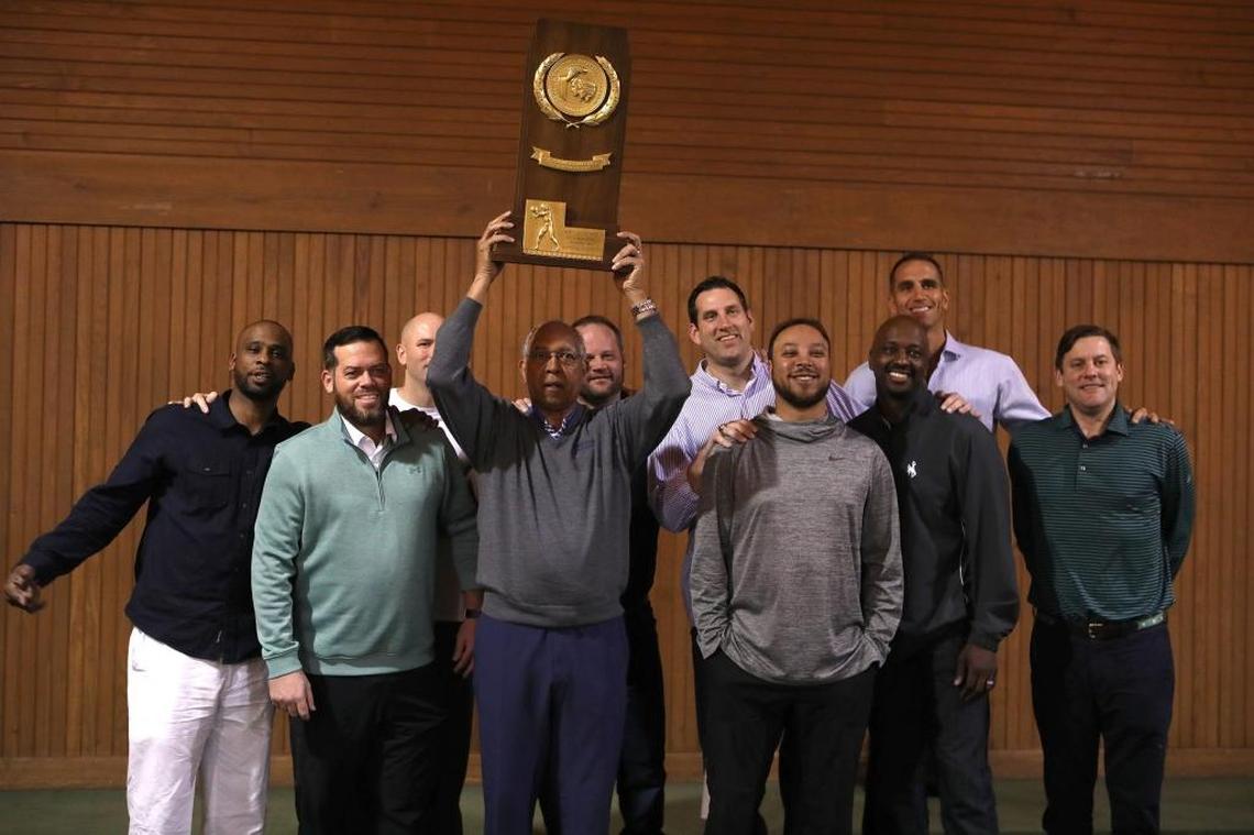 Tubby Smith raised the NCAA trophy as he posed with, from left, Wayne Turner, Steve Masiello, Jeff Sheppard, Cameron Mills, Scott Padgett, Saul Smith, Allen Edwards, Michael Bradley and Ryan Hogan of the 1998 national championship team Friday morning during the Maker’s Mark signing event at Keeneland. This year is the 20th anniversary of the “Comeback Cats” victory.