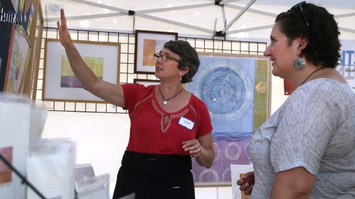 Elizabeth Foley explained her printmaking technique to Krissie Bentley at the Woodland Art Fair last August.