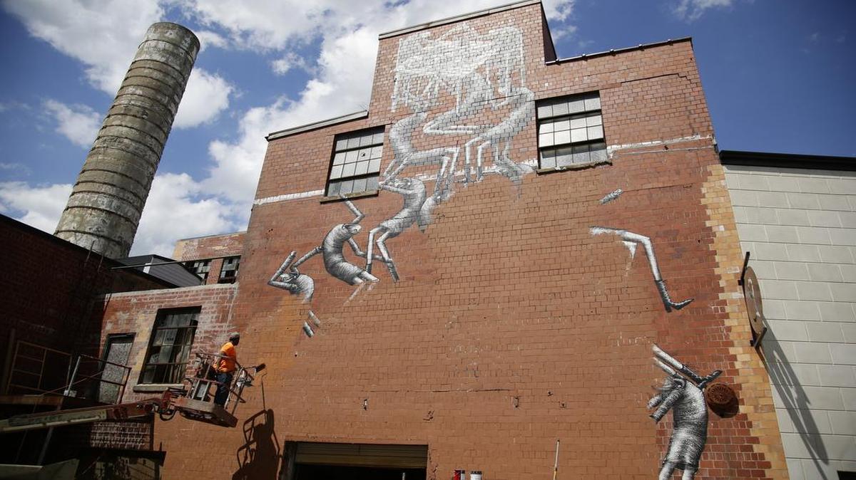 Josh Patton, painted over a mural by Phlegm on a building in the James Pepper distillery campus on Monday April 25, 2016 in Lexington, Ky.
