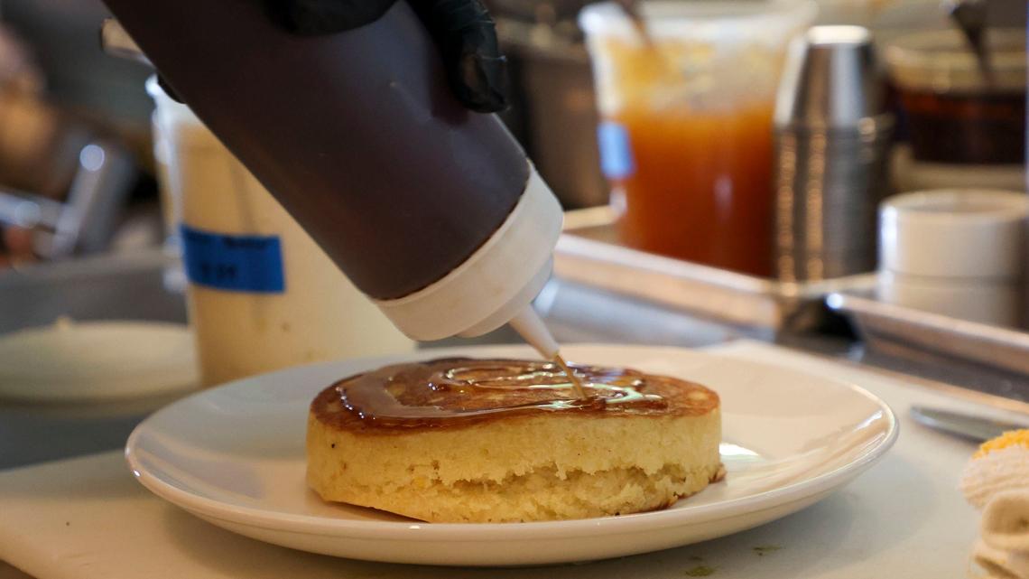 Beau’s Cafe chef and co-owner Spencer Sirles puts homemade maple syrup on an order of buttermilk pancakes. The maple syrup is made by reducing Evan Williams bourbon and adding other ingredients.