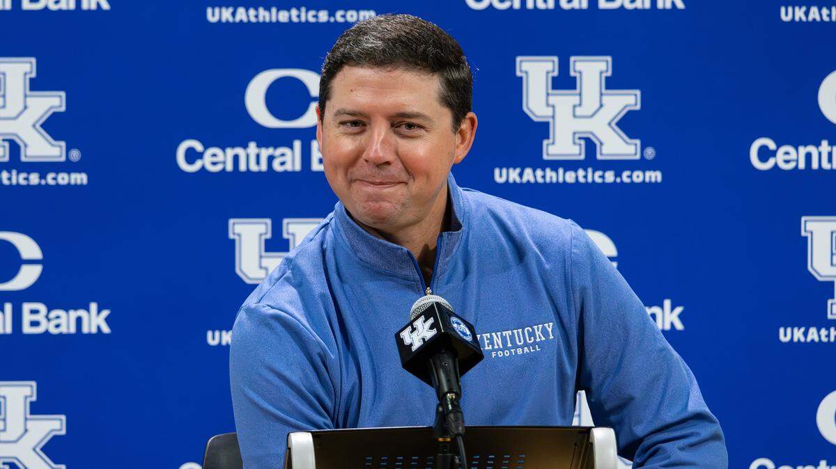 UK offensive coordiatnor Joe Sloan smiles during his introductory news conference in the media room at Kroger Field on Dec. 17, 2025 in Lexington, Ky.
