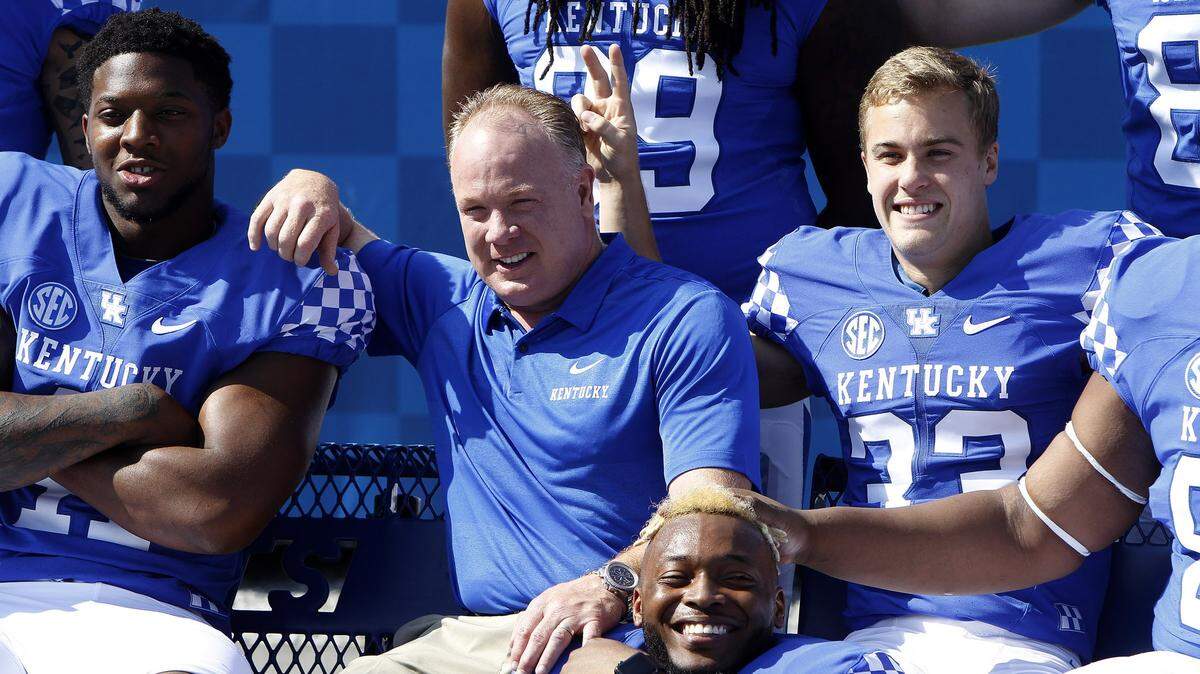 Senior David Bouvier gave bunny ears to Coach Mark Stoops during the Cats’ senior portrait during Media Day on Aug. 3. Coaches are calling the former Lexington Catholic standout a “warrior” who is playing his way onto the field.