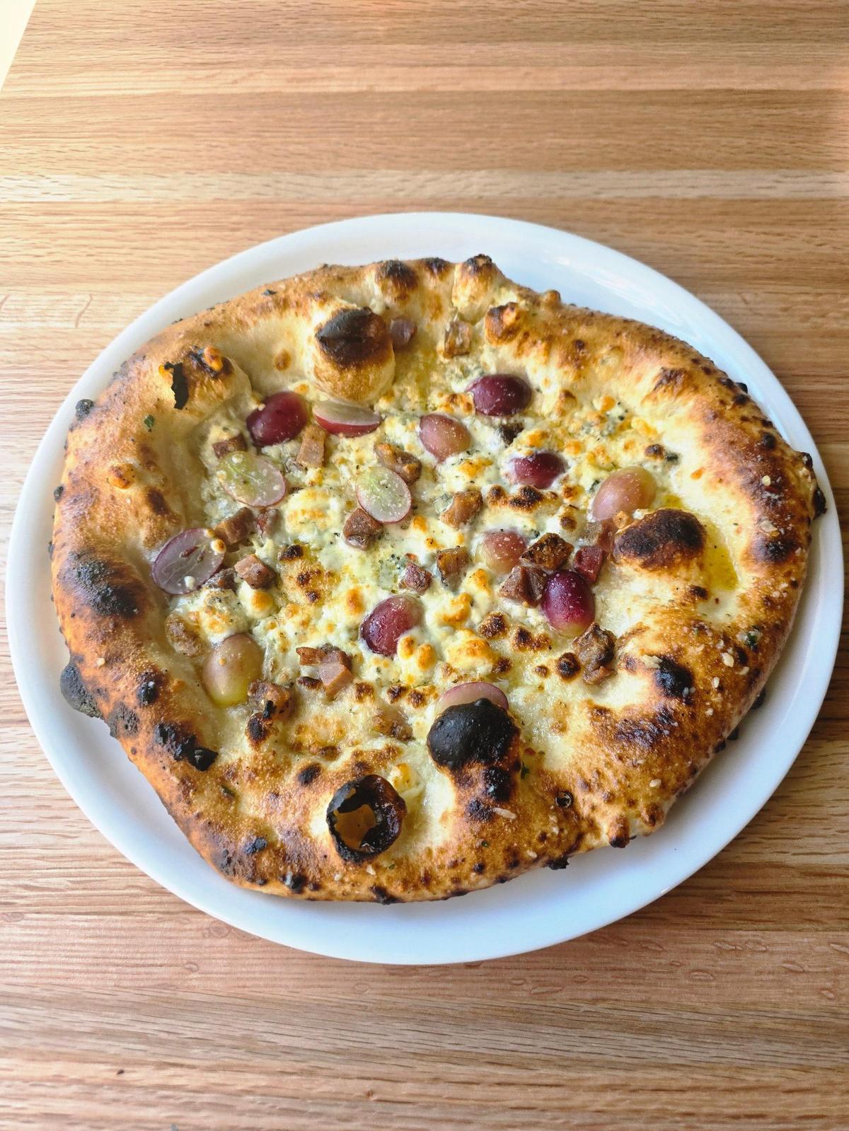 The Grape Ape ($18) pizza at Crust which is topped with crema sauce, roasted grapes, pancetta, Gorgonzola and arugula.