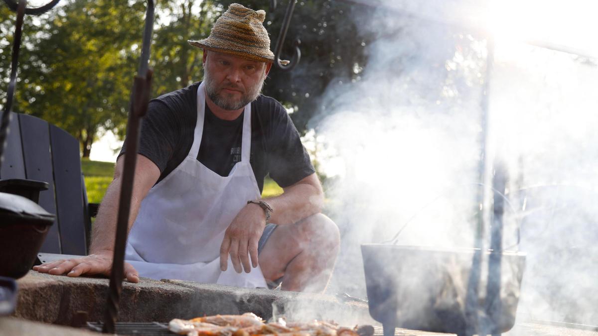 Tony Miller watches his meal cook over the campfire at Bourbon Barrel Cottages in Lawrenceburg, Ky.
