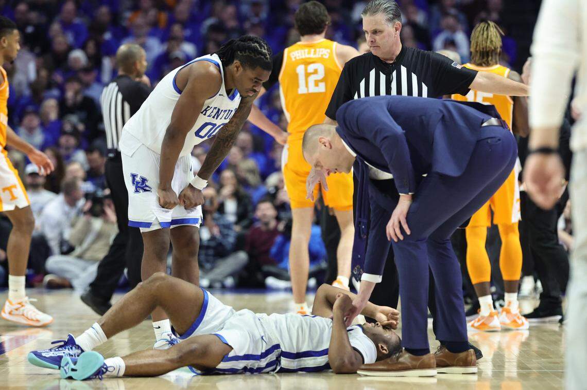 Kentucky’s Otega Oweh, left, and Mark Pope, right, check on an injured Lamont Butler during Tuesday’s game against Tennessee at Rupp Arena in Lexington, Ky., on Feb. 11, 2025.