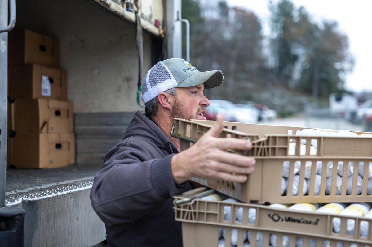 Eddie Stacy loads pork sausage donated by JSW Farm Chop Shop for the Hazel Green Food Project in Hazel Green, Ky., on Friday, Nov. 22, 2024.