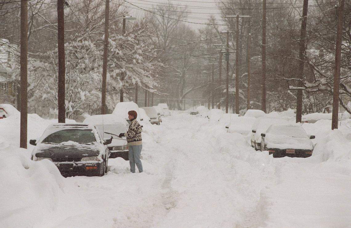 Leigh Anne Claywell clears the snow from her car on Oldham Ave. this morning as the snow storm continues on Friday Feburary 6, 1998. She got stuck on the street last night while visiting friends and had to spend the night. She was trying to dig out today to go to work.