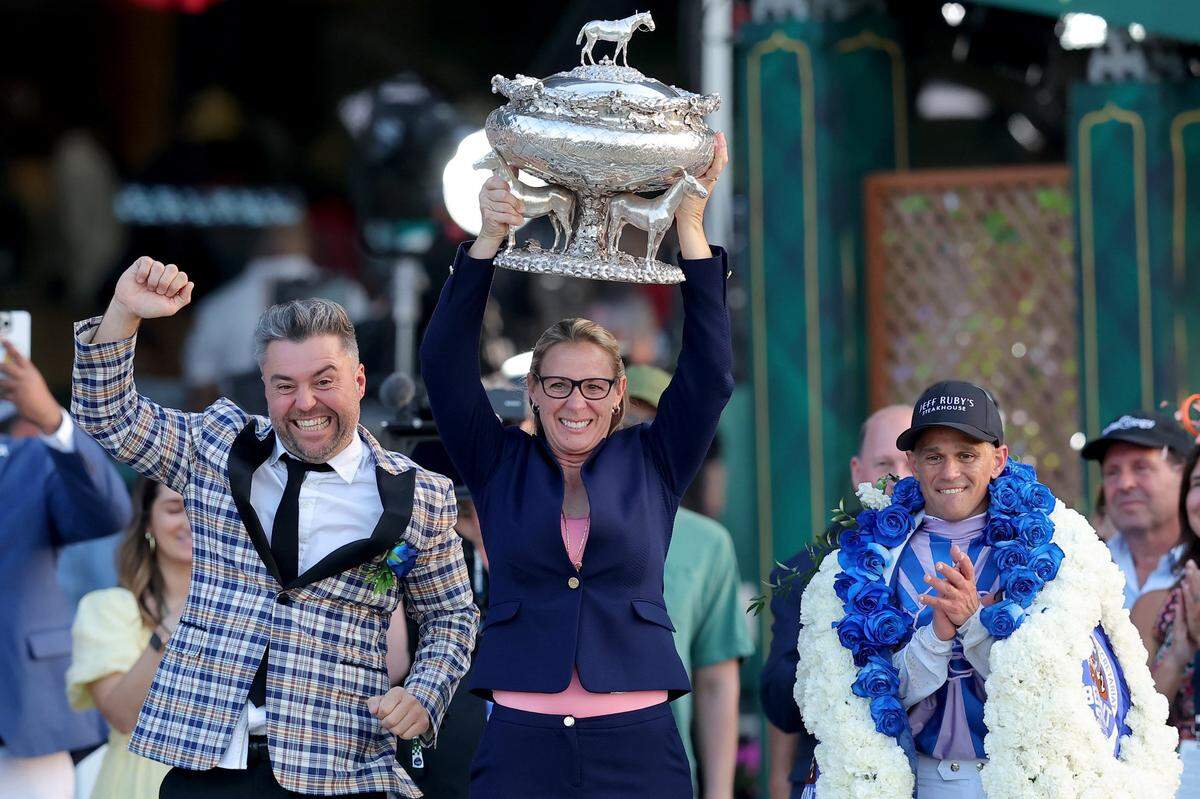 Arcangelo trainer Jena Antonucci, center, hoists the trophy alongside owner Jon Ebbert, left, and jockey Javier Castellano after their horse prevailed in the Belmont Stakes on Saturday.