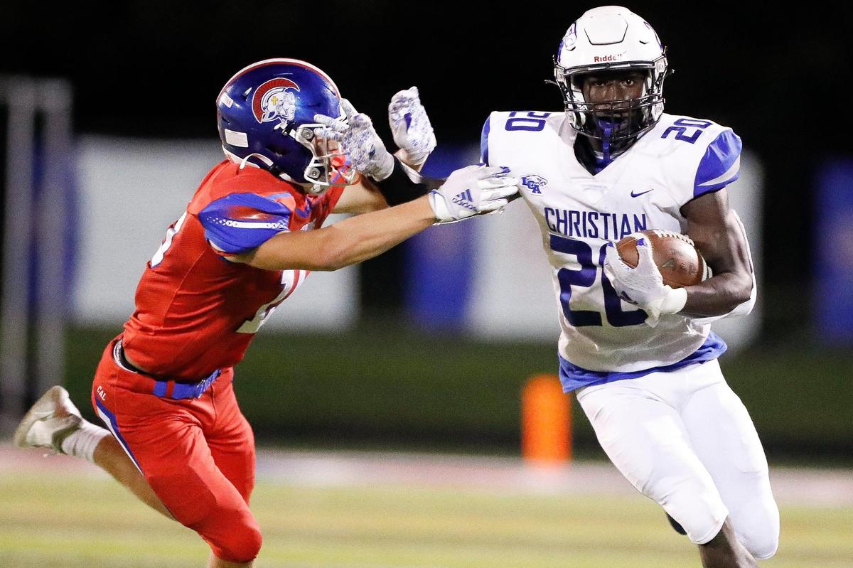 Lexington Christian’s Xavier Brown (20) runs the ball past Christian Academy-Louisville’s Isaac Patrick during a game on Sept. 10. LCA won 37-14.