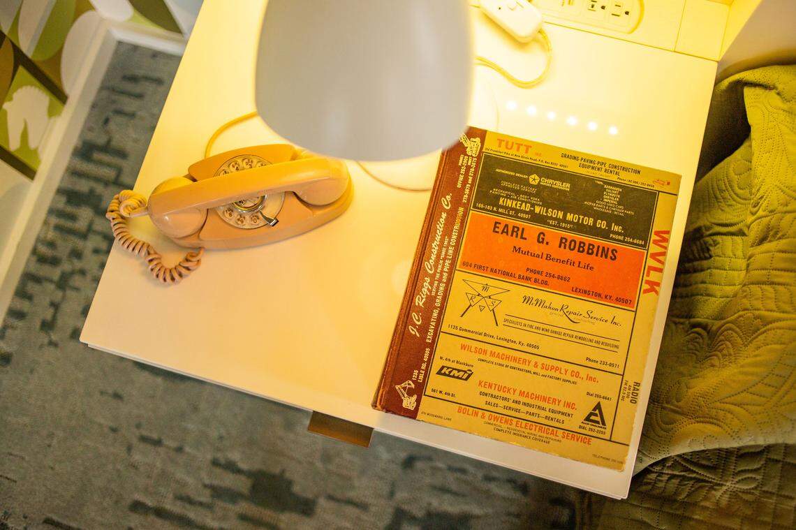 A telephone and phone book on a nightstand in the Harmon Room at the 21c.