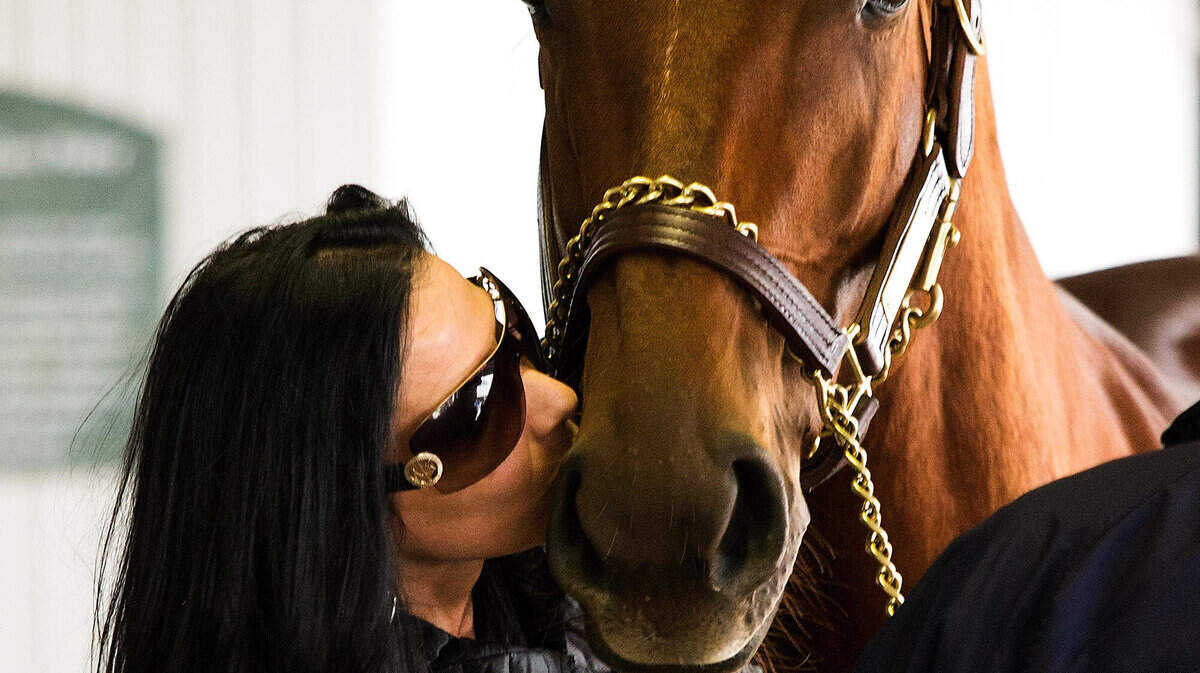 PARTING WITH A CHAMP: Exercise rider Jada Schlenk gave Groupie Doll a kiss goodbye Nov. 6 before the mare went to the sales ring, where she sold for $3.1 million during the Keeneland November Breeding Stock Sale. Fred and Buff Bradley had raised and raced the two-time Breeders’ Cup champ before deciding to sell her to help keep their small horse operation going.