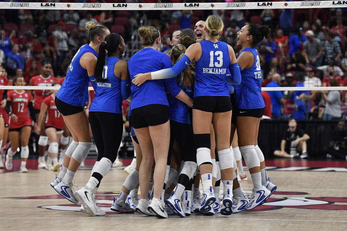 Kentucky volleyball players celebrate after defeating Louisville 3-2 in a match at the KFC Yum! Center in Louisville on Thursday.
