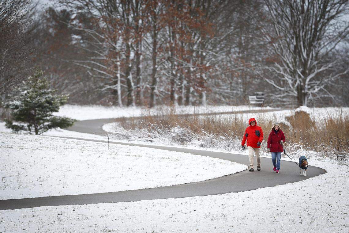 Gerhard Jinks, from left, and Joan Jinks, both of Lexington, Ky., walk Jake, their 10-year-old treeing walker coonhound, along a path at the University of Kentucky Arboretum in Lexington, Ky., Friday, Feb. 7, 2020. 