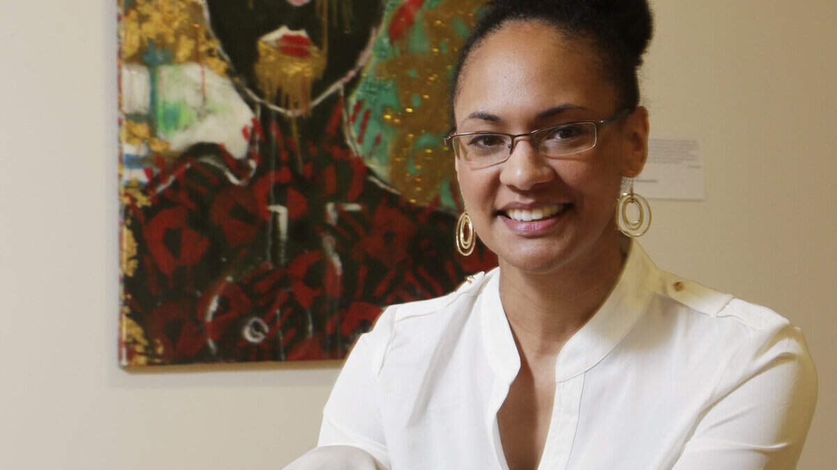 Rasheedah El-Amin, executive director of the Lyric Theatre with Punk Rock Mamiwata by Bianca Spriggs, part of the gallery exhibit Black Roots: Art Creations 2014  Lexington, Ky., on June 5, 2014. The display is currently running through October 11th with an official opening during the June 20th Gallery Hop. Photo by Pablo Alcala | Staff
