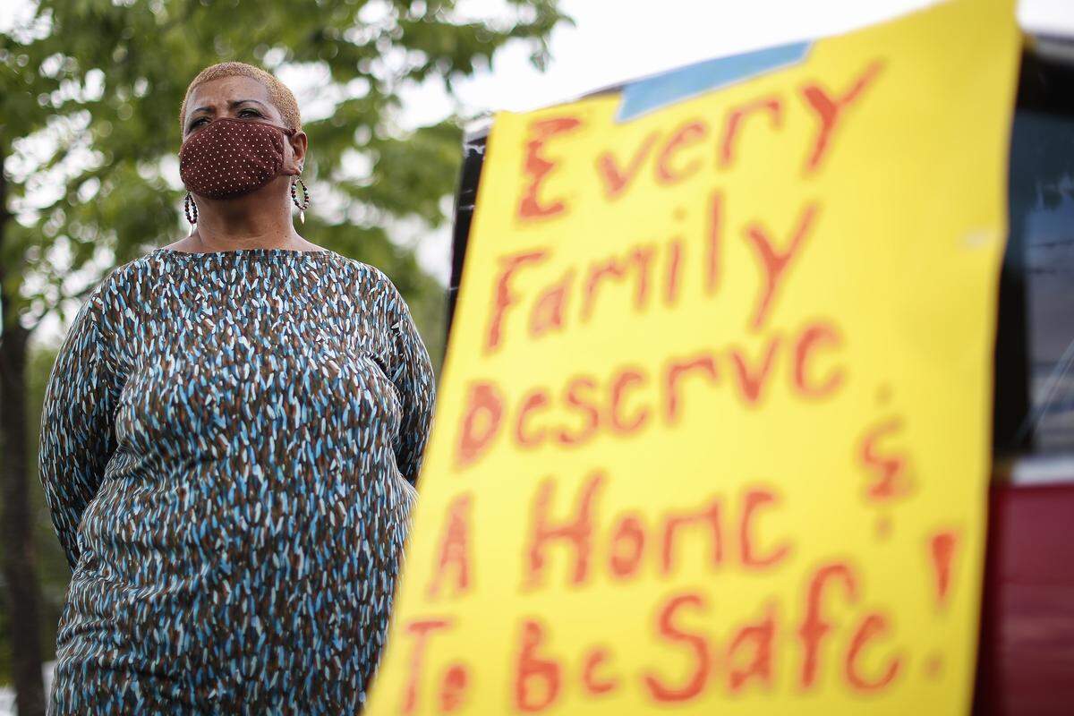 Cheryl Birch, of Lexington, Ky., listens as Fr. Dan Noll speaks during a drive-in rally to challenge proposed cuts to affordable housing in the city’s 2021 budget at Mary Queen of the Holy Rosary Catholic Church in Lexington, Ky., Thursday, May 21, 2020. The new budget would cut funding for the affordable housing Fund by $1.8 million.