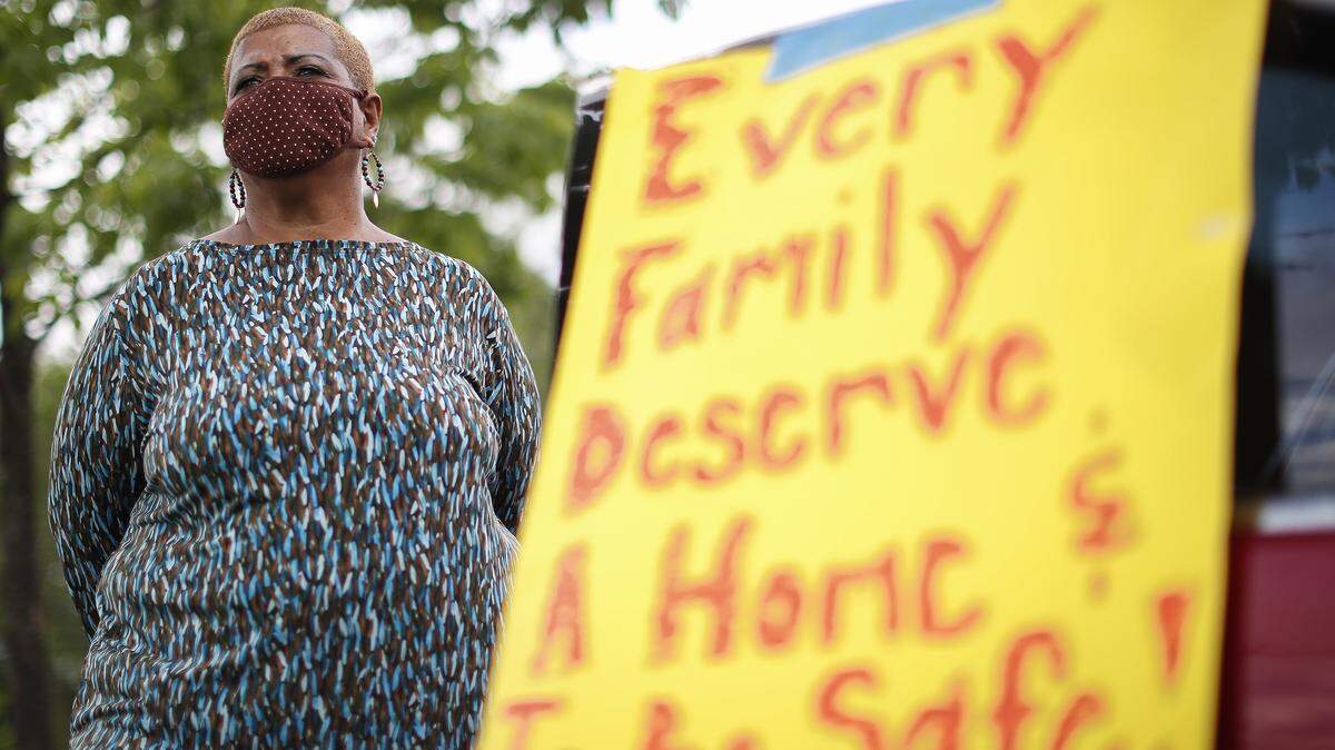 Cheryl Birch, of Lexington, Ky., listens as Fr. Dan Noll speaks during a drive-in rally to challenge proposed cuts to affordable housing in the city’s 2021 budget at Mary Queen of the Holy Rosary Catholic Church in Lexington, Ky., Thursday, May 21, 2020. The new budget would cut funding for the affordable housing Fund by $1.8 million.