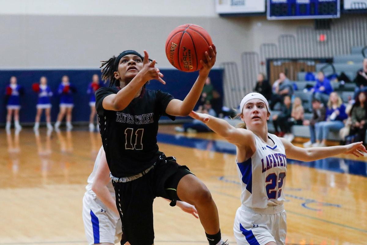 Tates Creek’s Miracle Morbley (11) splits a pair of defenders to score during Wednesday night’s win over Lafayette at Lexington Catholic.