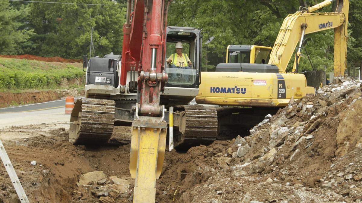 Joe Neff used a track hoe as a giant rock breaker as he buried pipes along Clays Mills Road on Tuesday.