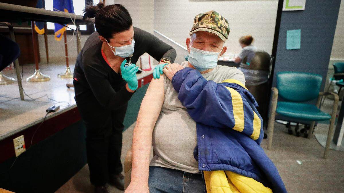 Clinical pharmacist Courtney Eatmon, of Lexington, Ky., administers a dose of Covid-19 vaccine to Navy Veteran Kenneth Adams, of Hazard, Ky., at the Lexington VA on Veterans Drive in Lexington, Saturday, Jan. 16. 2021.