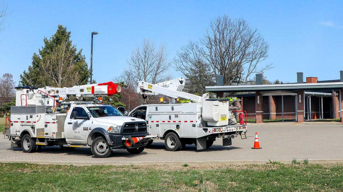 Trucks with the Public Service Company of Oklahoma sit in the parking lot of Glendover Elementary School Monday, March 6, 2023 in Lexington, Ky. Three days earlier a strong wind storm knocked out power to much of Lexington, Ky.