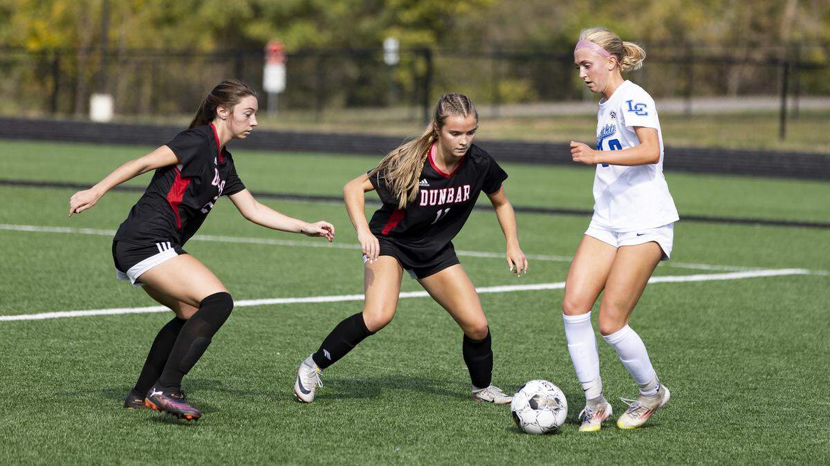 Paul Laurence Dunbar’s Kaleigh Potts, left, and Layla Flynn cornered Lexington Catholic’s Joanna Bryant during the 11th Region girls soccer tournament championship game at Scott County High School in Georgetown on Saturday.
