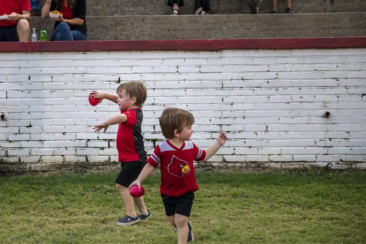 Sam Youngblood, 4, and Max Youngblood, 2, sons of Mayfield’s cheer coach, play catch before the Mayfield and Graves County football game.