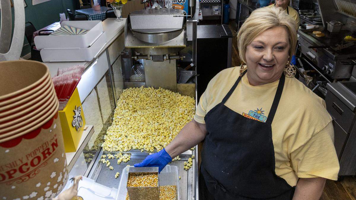 Drive-In Diner co-owner Ruby Rice next to the drive-in’s original popcorn machine inside the former concession stand of the Mountain View Drive-In in Stanton, Ky.