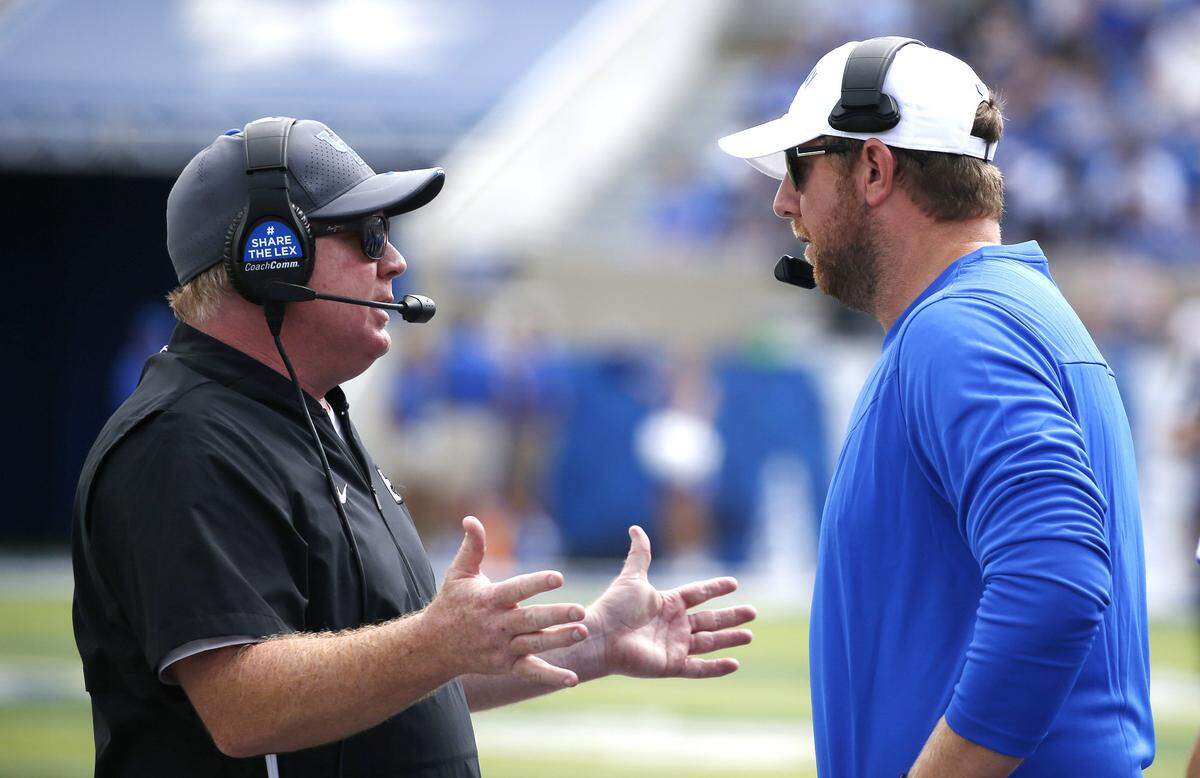 The return of Liam Coen, right, to run the offense for Mark Stoops, left, has many Kentucky Wildcats football fans energized for 2023. Coen, UK’s offensive coordinator during the 10-3 2021 season, spent last year as the OC for the NFL’s Los Angeles Rams.
