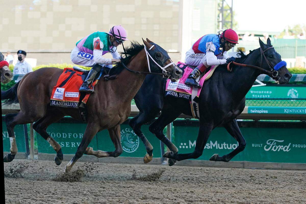 John Velazquez, right, rides Medina Spirit ahead of Florent Geroux aboard Mandaloun to win the 147th Kentucky Derby at Churchill Downs on Saturday.