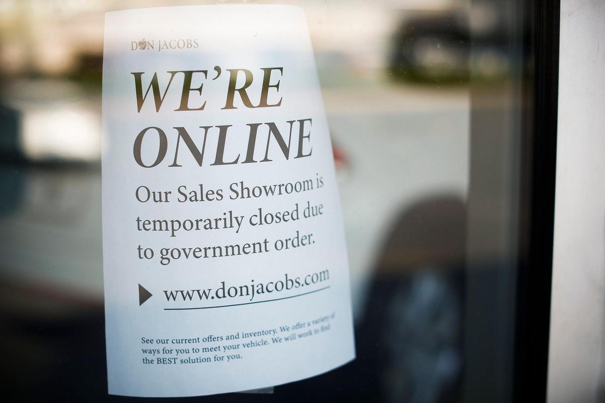 A sign alerting customers that the showroom is closed is posted Friday on the door of the Volkswagen service center at Don Jacobs dealerships off Nicholasville Road.