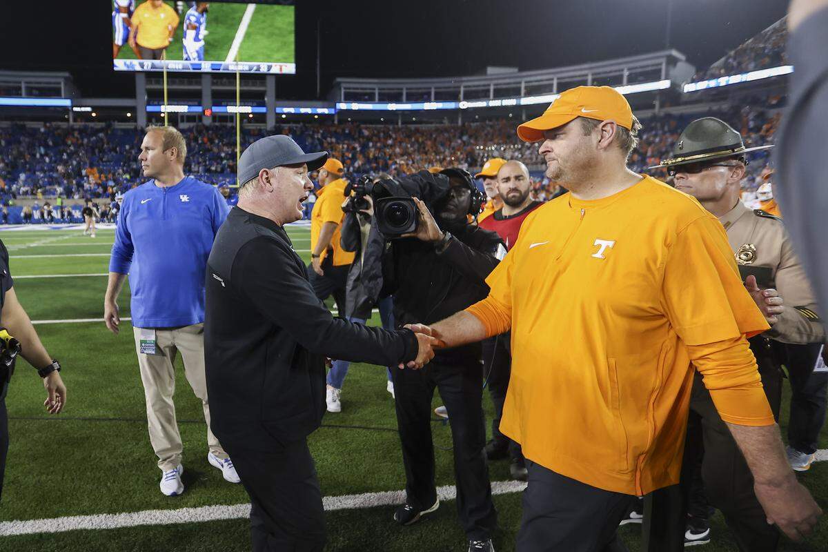 Kentucky coach Mark Stoops, left, shook hands with Tennessee head man Josh Heupel after UT’s 33-27 win over UK at Kroger Field on Oct. 28, 2023.