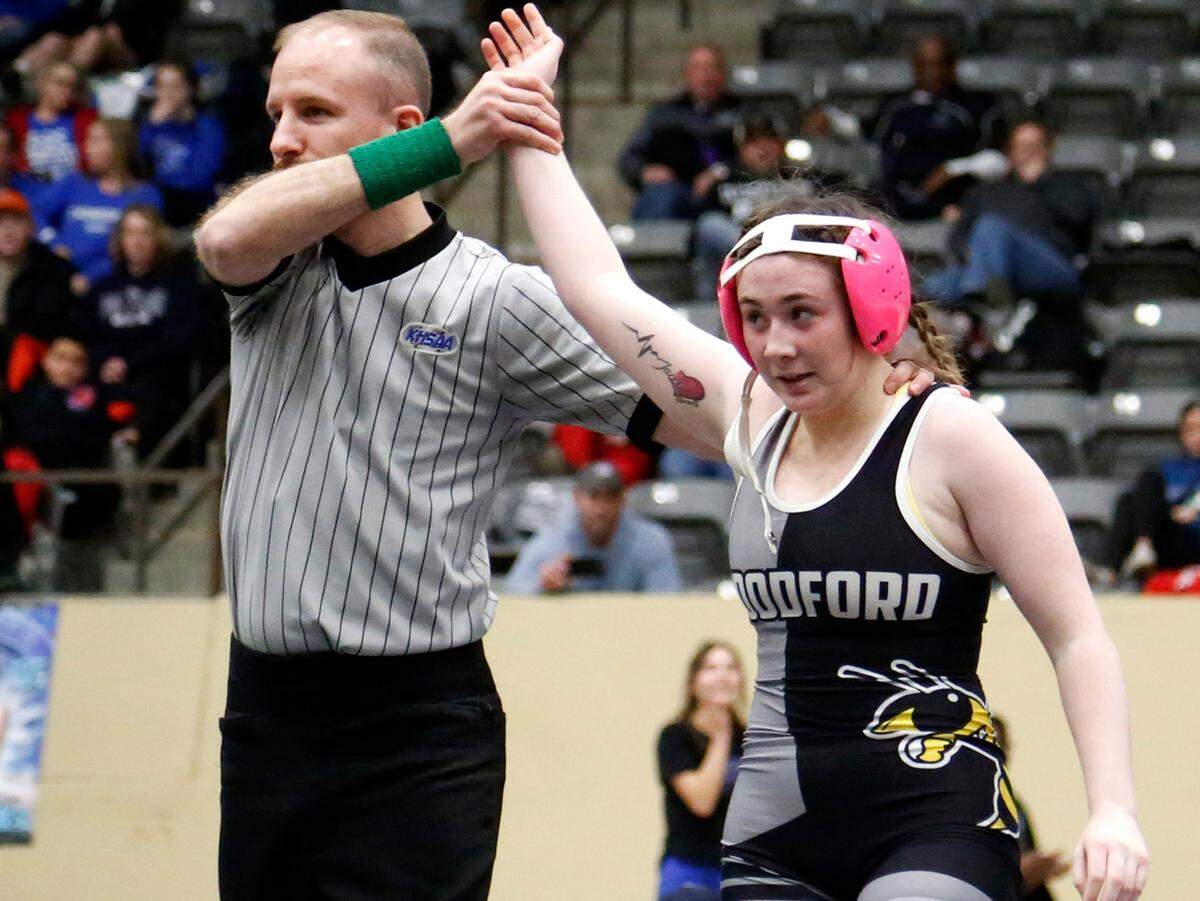 Woodford County’s Lacey Gilbert gets her hand raised in victory after she pinned her opponent in the 126 division finals.