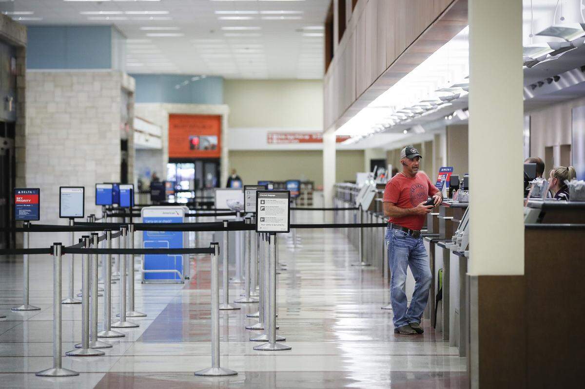 Trampas Cook, of Parksville, Ky., speaks with airline employees after learning his flight was canceled at the Blue Grass Airport in Lexington, Ky., Tuesday, March 24, 2020. Cook has been rebooked on a flight that is scheduled to leave Wednesday morning.