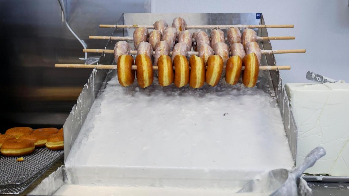 Yeast doughnuts get a coating of glaze after being fried at Jeff’s Donuts, Thursday, Jan. 23, 2025, in Lexington, Ky. The new-to-Lexington shop has more than 30 varieties of doughnuts on its menu plus a rotation of specials.