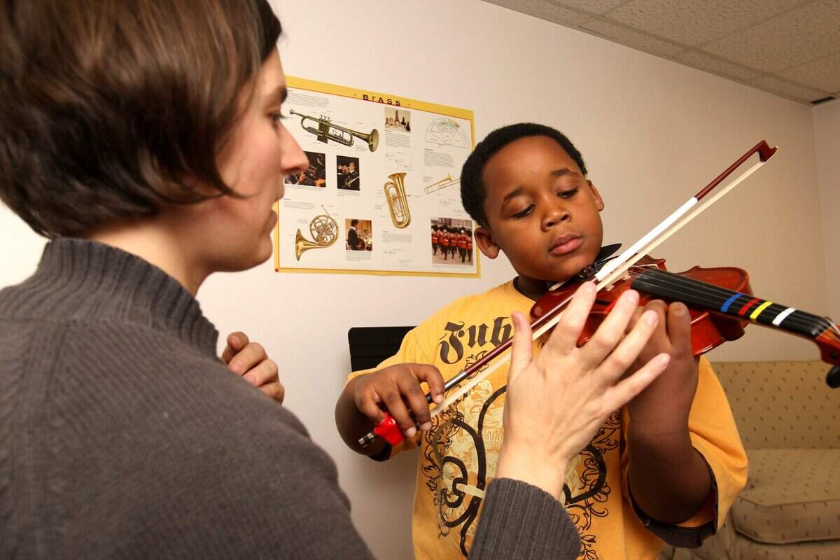 Volunteer instructor Sarah Kehrberg gives a private lesson to Giovanni Watson, 5, at Central Music Academy in Lexington, Ky., Monday evening, December 8, 2008. Watson has played violin for two years. Photo by Matt Goins