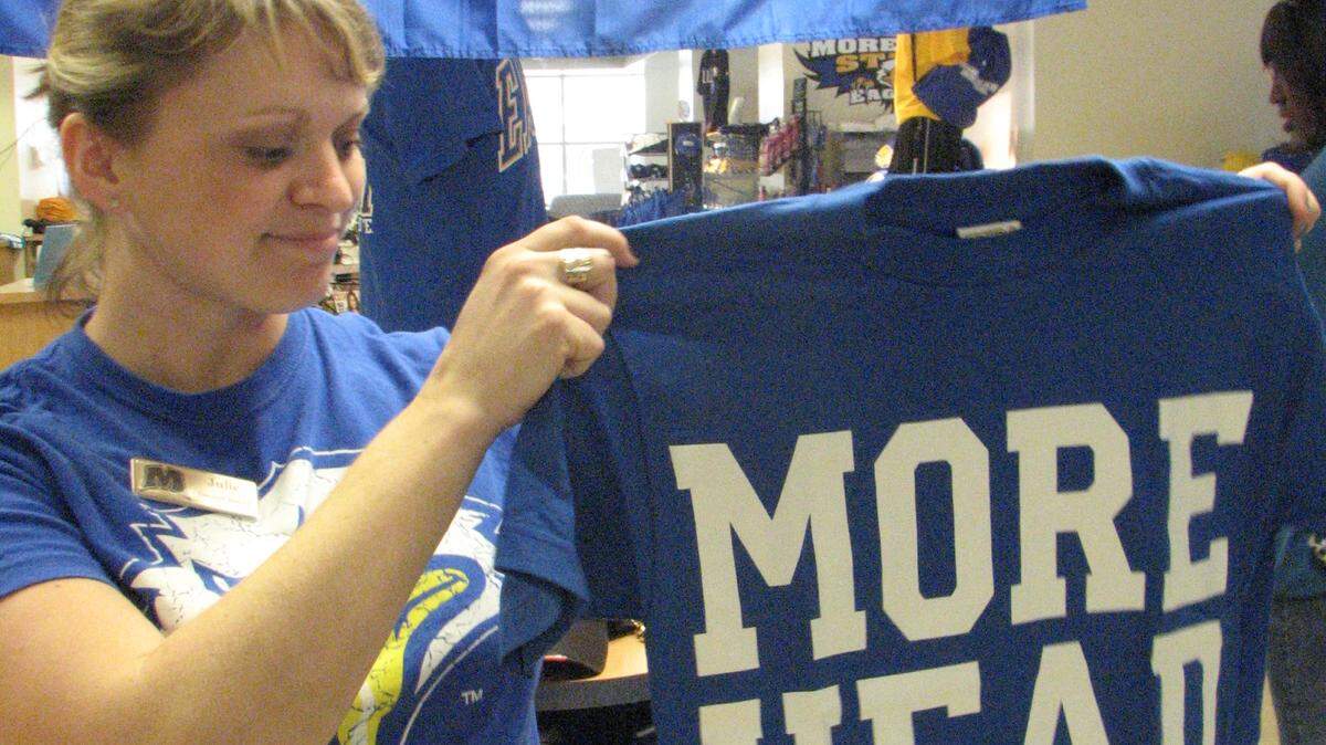 Morehead State University bookstore employee Julie Ferguson displayed a fast-selling T-shirt Friday in Morehead. Morehead's basketball team upset the University of Louisville on Thursday.        