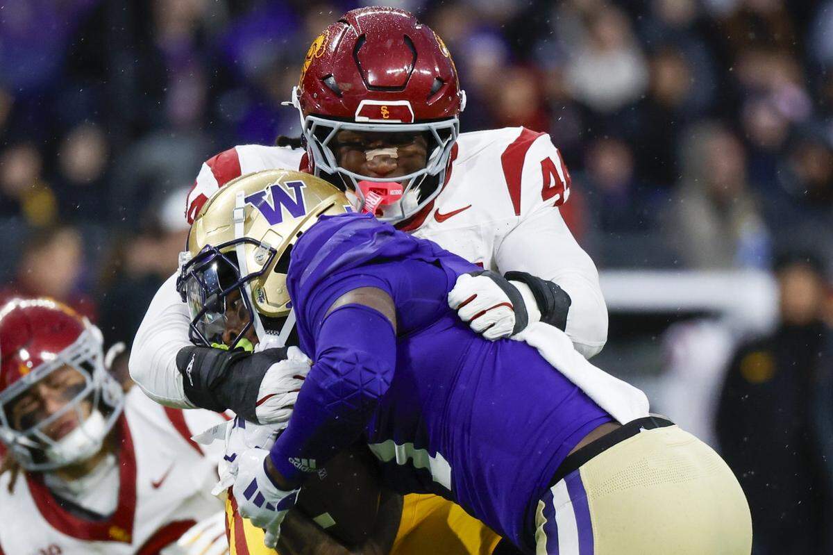Nov 2, 2024; Seattle, Washington, USA; USC Trojans defensive end Sam Greene (44) tackles Washington Huskies running back Jonah Coleman (1) during the second quarter at Alaska Airlines Field at Husky Stadium. Mandatory Credit: Joe Nicholson-Imagn Images