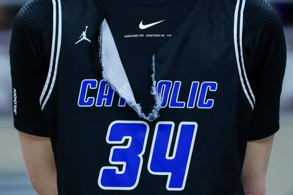 Lexington Catholic’s Reece Potter (34) stands with a torn jersey for an all region team award after losing the 11th Region Tournament Championship game against Frederick Douglass at Alumni Coliseum in Richmond, Ky., Monday, March 6, 2023. The 7-foot center Potter had a game-high 19 points to go with eight rebounds but it wasn’t enough to send the Knights to Rupp Arena for the Sweet Sixteen.
