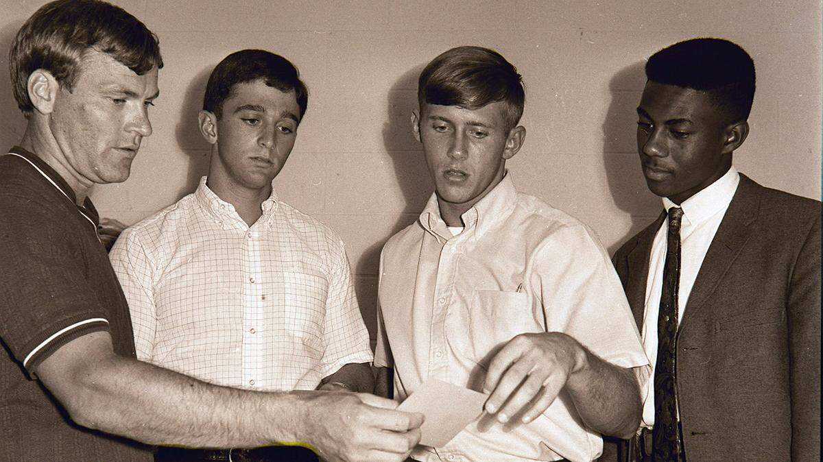 Kentucky track coach Press Whelan, left, checked out the class schedule of, from left, Barry Lints, Ray Sabbatine and Jim Green in 1967.