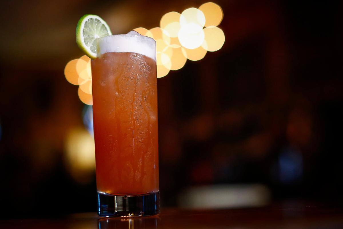 That Tequila Thing made with tequila, pineapple juice, lime juice, simple syrup, vanilla extract and bitters served over ice and garnished with slice of lime at Arcadium.